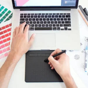 Diseñador creando una identidad visual con paleta de colores y tableta gráfica